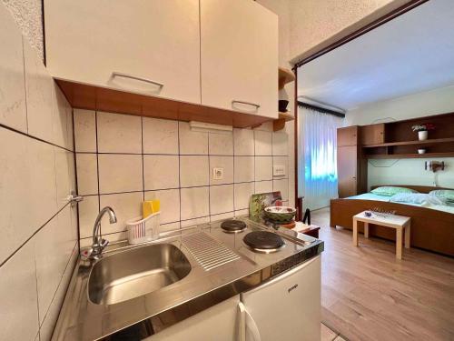 a kitchen with a sink and a room with a bed at Studio in Dramalj 45735 in Dramalj