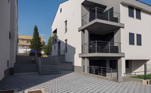 ein weißes Gebäude mit Treppen und Balkonen darauf in der Unterkunft Studio in Biograd na Moru - Biograd Riviera 45742 in Biograd na Moru