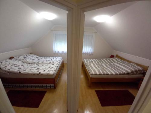 2 camas en una habitación con 2 ventanas en Apartments in Borgata - Nordtransdanubien 45815, en Mesteri
