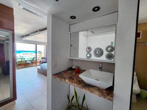 a bathroom with a sink and a mirror at Beachfront apartments Cancun in Cancún