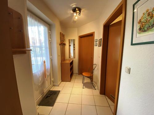 um corredor com uma porta e uma cadeira num quarto em Seehund em Schönberger Strand