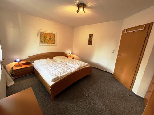 um quarto com uma cama e duas mesas de cabeceira e uma porta em Seehund em Schönberger Strand