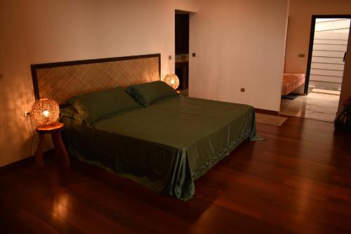 a bedroom with a bed and a lamp on a wooden floor at Fare O Mape in Faaa
