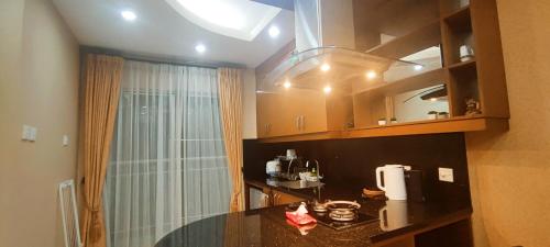 a kitchen with a glass table and a window at Classy! 2BR Medit2 West Jakarta in Jakarta