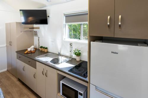 a small kitchen with a sink and a refrigerator at BIG4 Tasman Holiday Parks - Rowes Bay in Townsville