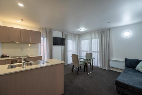 a kitchen and living room with a table and a couch at Mercure Wellington Central City Hotel and Apartments in Wellington