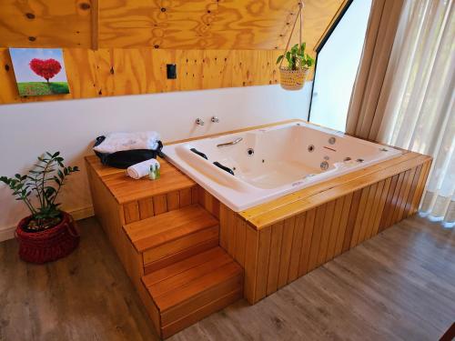 una bañera de hidromasaje en un baño con paredes de madera en Vila ALegre Hospedagem, en Campo Alegre