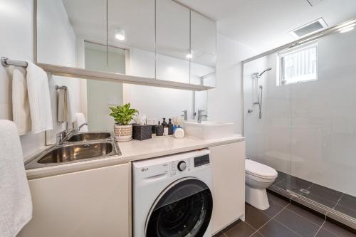 a white bathroom with a washing machine and a sink at Avon Lane @ Gilberton in Adelaide