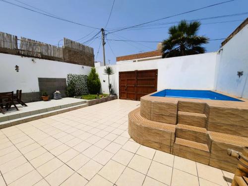 un patio trasero con piscina y una casa en Casa de playa en Punta Hermosa, en Punta Hermosa