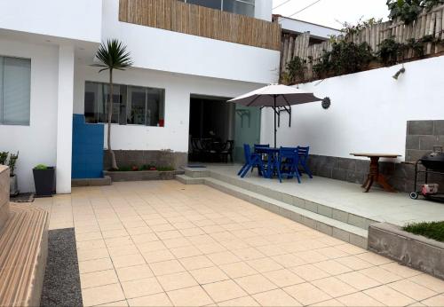 un patio con mesa, sillas y sombrilla en Casa de playa en Punta Hermosa, en Punta Hermosa