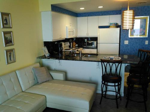 a living room with a couch and a kitchen at Ocean Walk Resort - Fabulous Ocean Front View in Daytona Beach