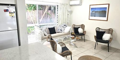 een woonkamer met een bank en een tafel bij Mango Tree Holiday Apartments in Port Douglas