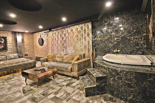 a living room with a couch and a tub at Elegant House Otel in Ankara