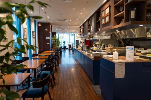 a restaurant with blue counters and tables and chairs at Sotetsu Fresa Inn Ginza-Nanachome in Tokyo