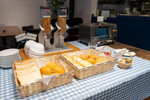 a table with two baskets of bread and baskets of cheese at Sotetsu Fresa Inn Ginza-Nanachome in Tokyo