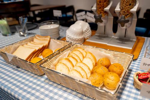 a table with two trays of bread and other foods at Sotetsu Fresa Inn Ginza-Nanachome in Tokyo