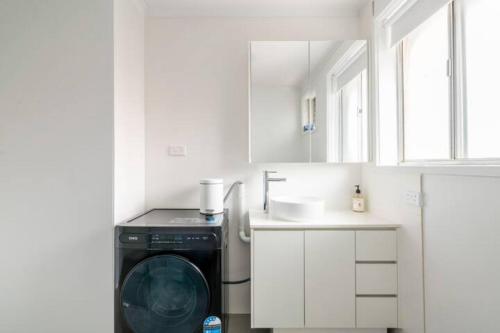 uma cozinha com uma máquina de lavar roupa e um lavatório em Quiet & Private with city access and free wifi em Melbourne
