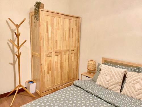 a bedroom with a bed and a wooden door at Cozy 1 BR Scandinavian/Tropical Condo with Balcony & Parking in Manila