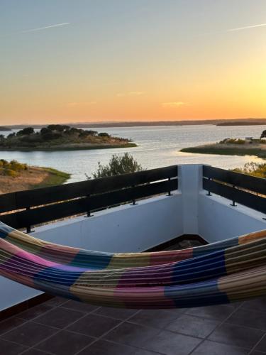 a hammock sitting on top of a balcony overlooking the water at Estrela Villas in Estrela
