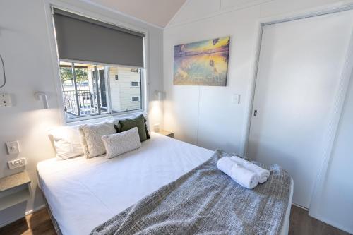 a bedroom with a white bed and a window at BIG4 Tasman Holiday Parks - Rowes Bay in Townsville