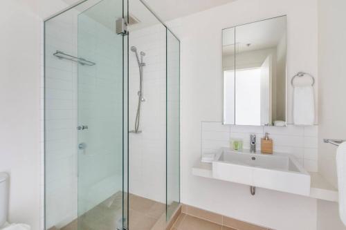 La salle de bains est pourvue d'une douche en verre et d'un lavabo. dans l'établissement Aloft at Era with Sweeping Balcony Views, à Melbourne