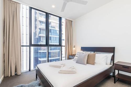 a bedroom with a large bed and a large window at Cityscape Serenity with Pool near Gabba and CBD in Brisbane