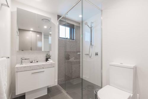 a bathroom with a shower and a toilet and a sink at Cityscape Serenity with Pool near Gabba and CBD in Brisbane