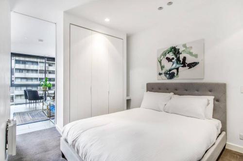a bedroom with a large white bed and a window at Experience Elegance at a Resort-style Urban Oasis in Melbourne