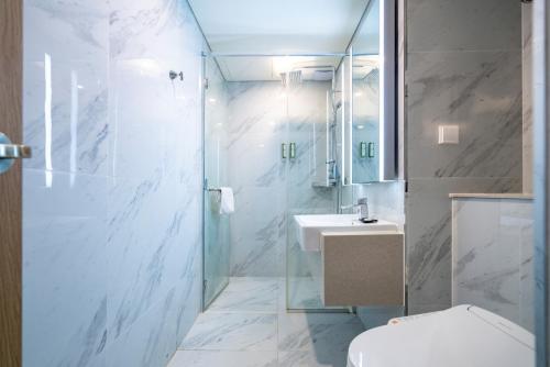 a bathroom with a shower and a toilet and a sink at Centum Business Hotel in Busan
