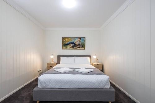 a bedroom with a bed with two books on it at Fernberg Cottage - Sunny Queenslander Charm in Brisbane