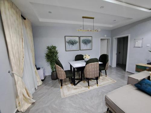 ein Wohnzimmer mit einem Esstisch und Stühlen in der Unterkunft The Palladium Apartments in Ebute Lekki