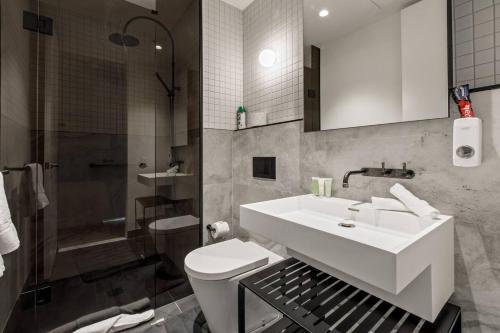 a bathroom with a sink and a toilet and a shower at The Claremont - Refined Resort Style Living in Melbourne