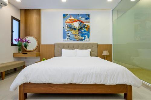 a bedroom with a bed and a painting on the wall at Charming Luxury Beach Villa Da Nang in Da Nang