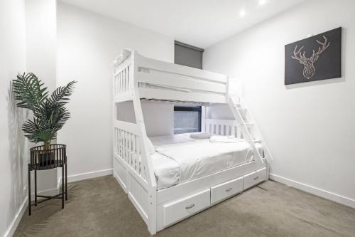 a white bunk bed in a white room at Live Lakeside in an Alfresco Albert Park Retreat in Melbourne