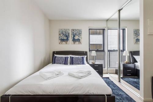 a bedroom with a large bed with two towels on it at Little Lonsdale Loft - Primely Located in the CBD in Melbourne