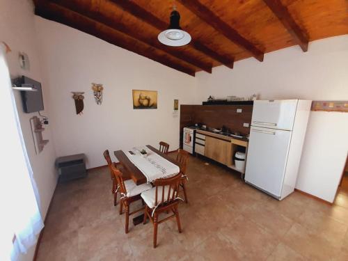 eine Küche mit einem Tisch und einem weißen Kühlschrank in der Unterkunft Brisa de Patagonia- Maiten in Trevelín