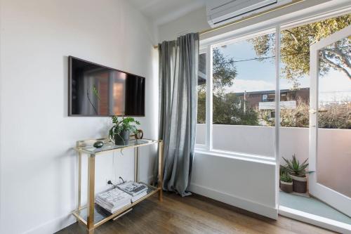 a living room with a tv and a window at Sage Haven - Laidback St Kilda Beach Living in Melbourne