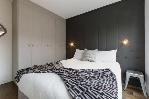 a bedroom with a large bed with a black wall at Sage Haven - Laidback St Kilda Beach Living in Melbourne