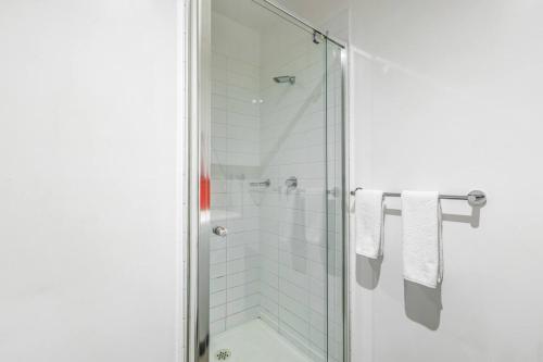 a bathroom with a shower with white towels at Little Lonsdale Loft - Primely Located in the CBD in Melbourne