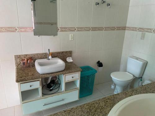 a bathroom with a sink and a toilet at Casa amarela in Campos