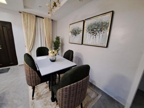 a dining room with a white table and chairs at The Palladium Apartments in Ebute Lekki