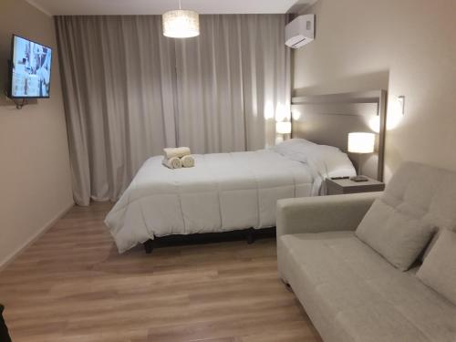 une chambre d'hôtel avec un lit et un canapé dans l'établissement Apart 312 Casa de Playa, à Necochea