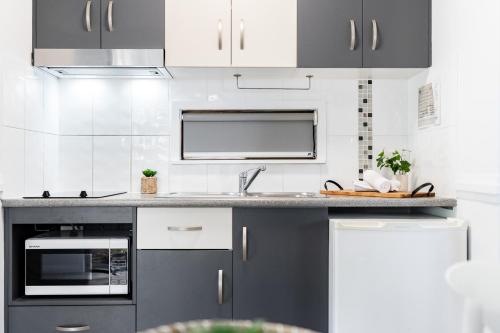 a kitchen with gray and white cabinets and a sink at BIG4 Tasman Holiday Parks - Rowes Bay in Townsville