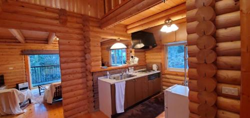 uma cozinha num chalé de madeira com um lavatório em Rental Cottage Forest Breathing - Vacation STAY 13733 em Saga