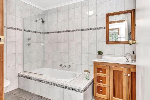 a bathroom with a tub and a sink at 'Harmony Lodge' A Cheerful Beachside Refresh in Adelaide