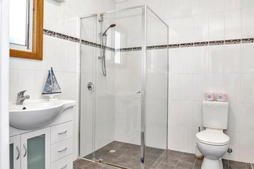 a bathroom with a shower and a toilet and a sink at 'Harmony Lodge' A Cheerful Beachside Refresh in Adelaide