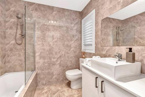 a bathroom with a sink and a toilet and a shower at 'Christies Chic' A Family Getaway by the Beach in Adelaide