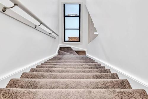 a staircase in a house with a window at 'Christies Chic' A Family Getaway by the Beach in Adelaide