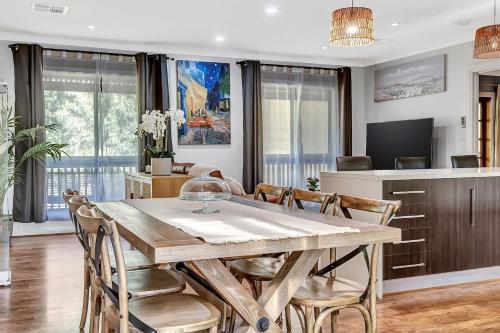 a dining room with a wooden table and chairs at Stump Hill Estate - A Unique Stay with Mini Golf in McLaren Vale