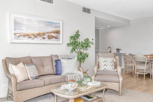 a living room with a couch and a table and chairs at Hamptons-inspired Waterfront Living on Moana Beach in Adelaide